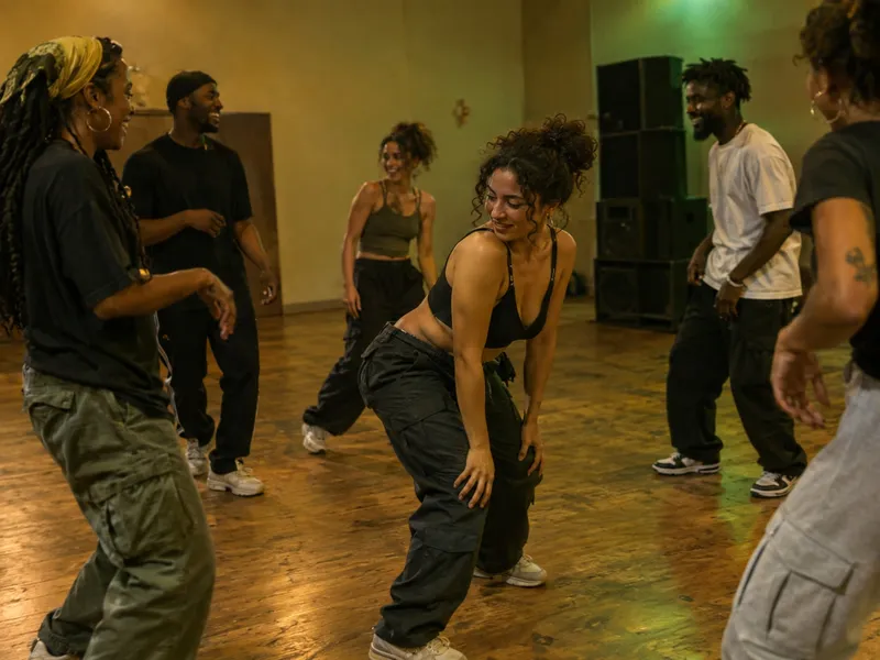 Adultos numa aula de dancehall a rir entre passos