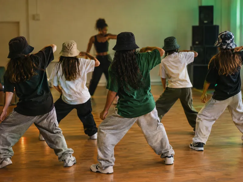 Um grupo de crianças dos 9 aos 13 anos a ensaiar uma coreografia de dancehall em linha