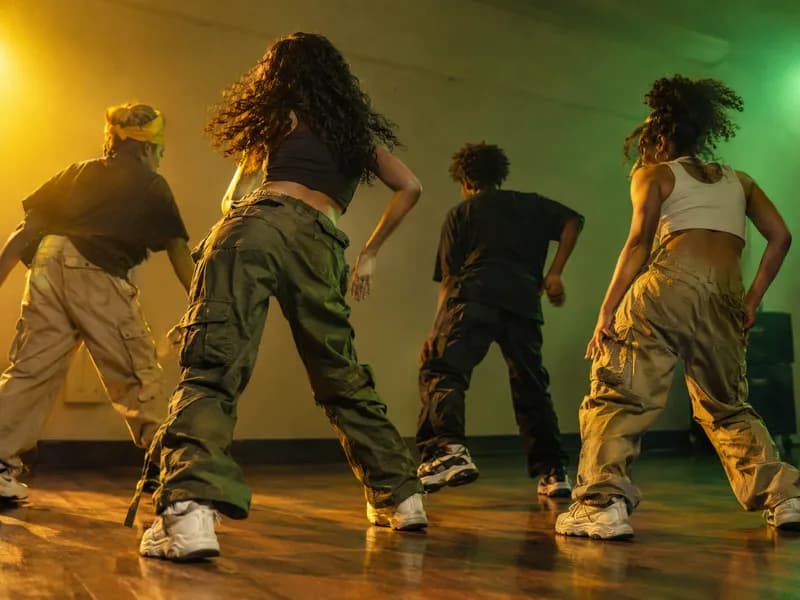 Adolescentes em streetwear a fazer um passo de dancehall cheio de energia